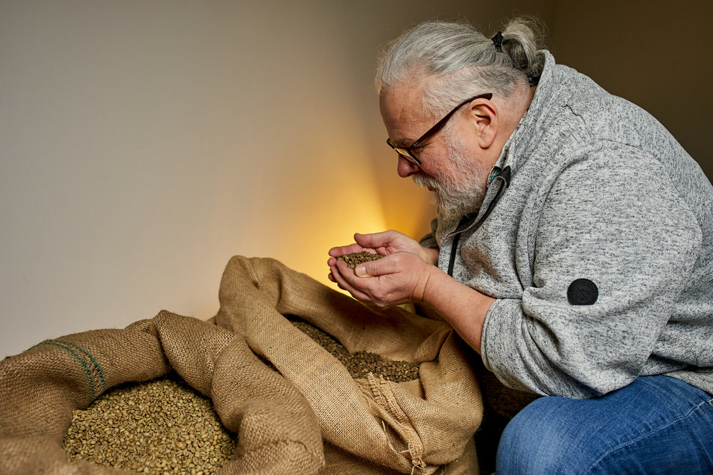 Kaffeeröster begutachtet den frischen, ungerösteten Kaffee in einem Kaffeesack